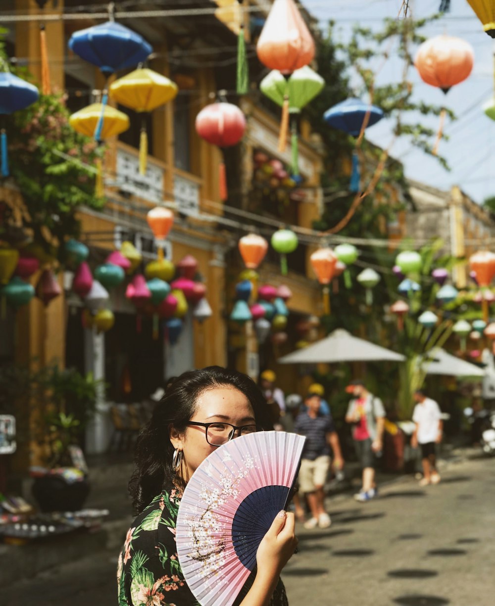 woman in black and white striped shirt holding pink hand fan