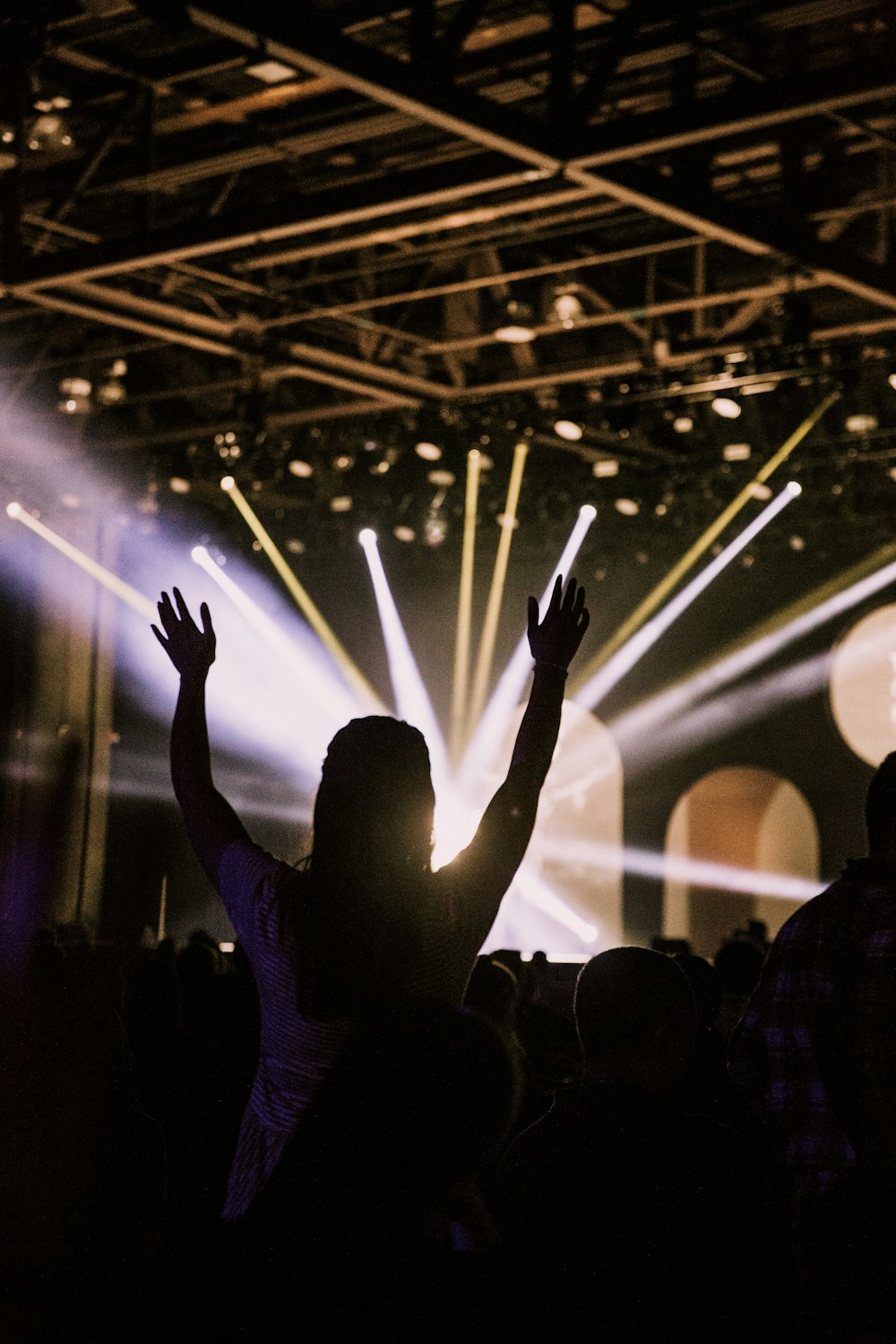 people raising their hands in front of stage