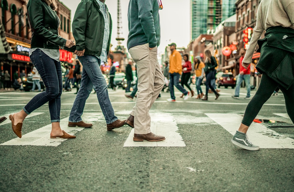 persone che camminano sulla corsia pedonale durante il giorno