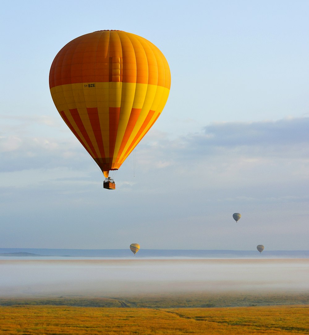 Globo aerostático amarillo y rojo en el aire durante el día