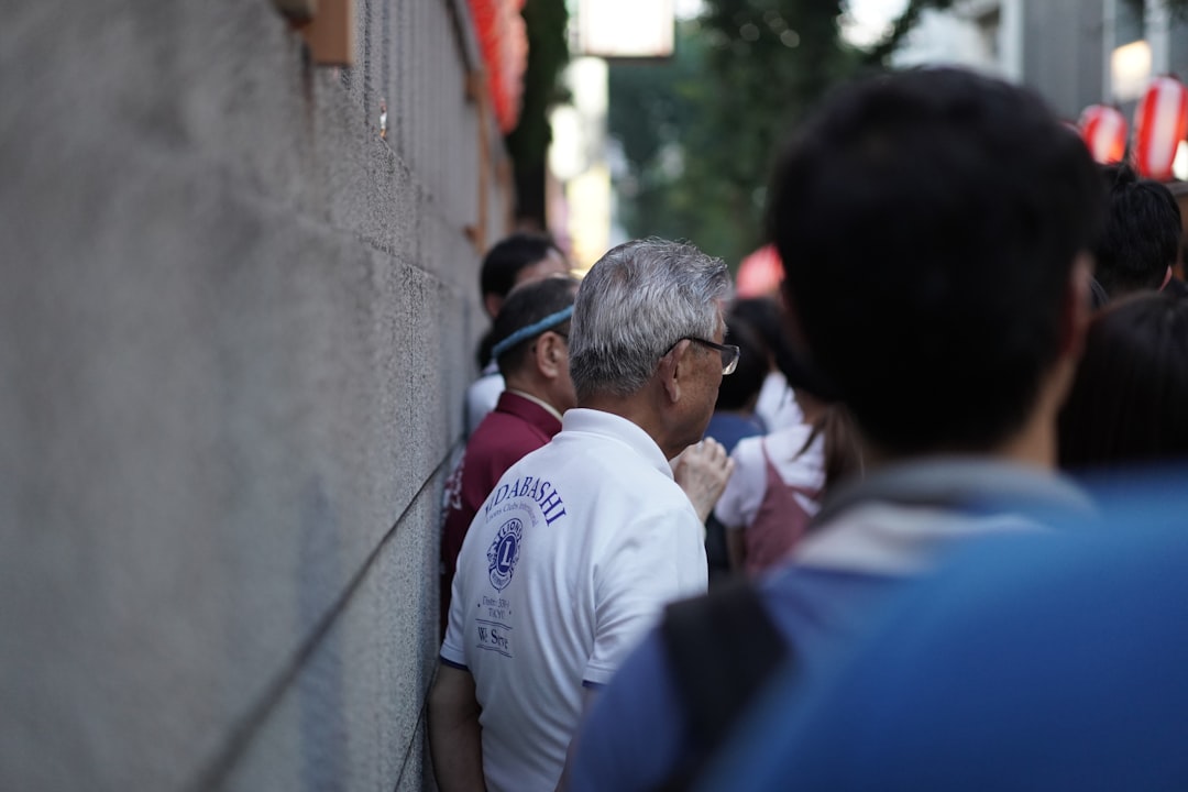 man in white crew neck t-shirt standing near man in blue t-shirt