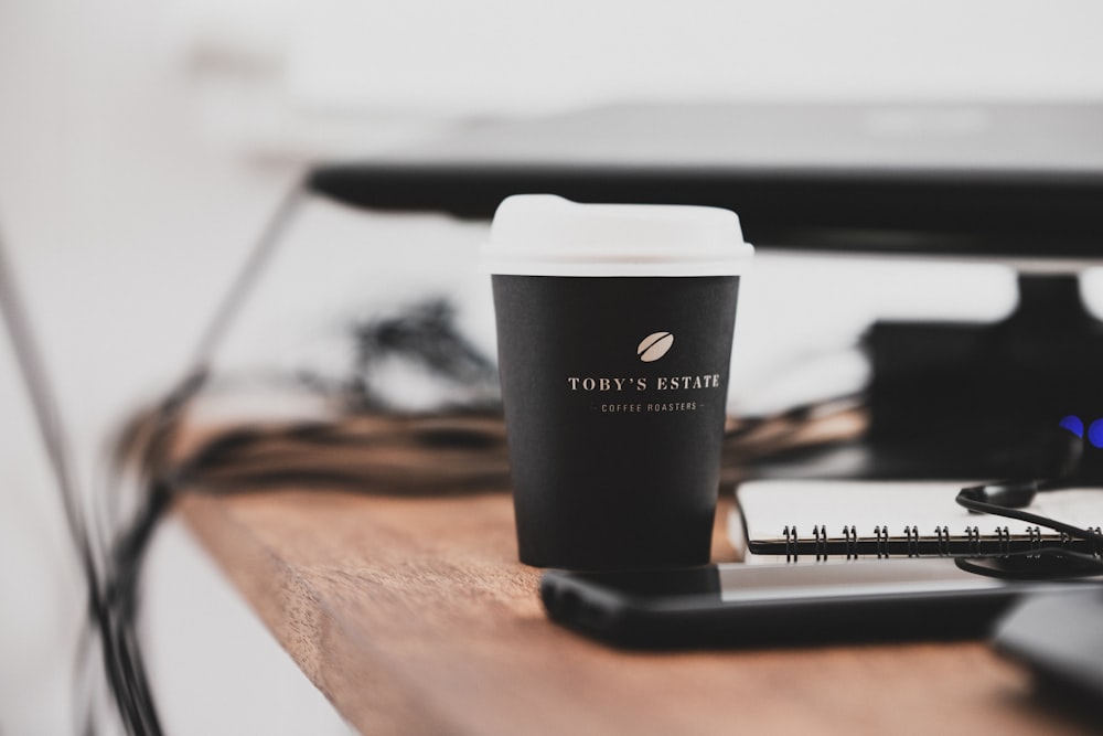 black and white plastic cup on brown wooden table