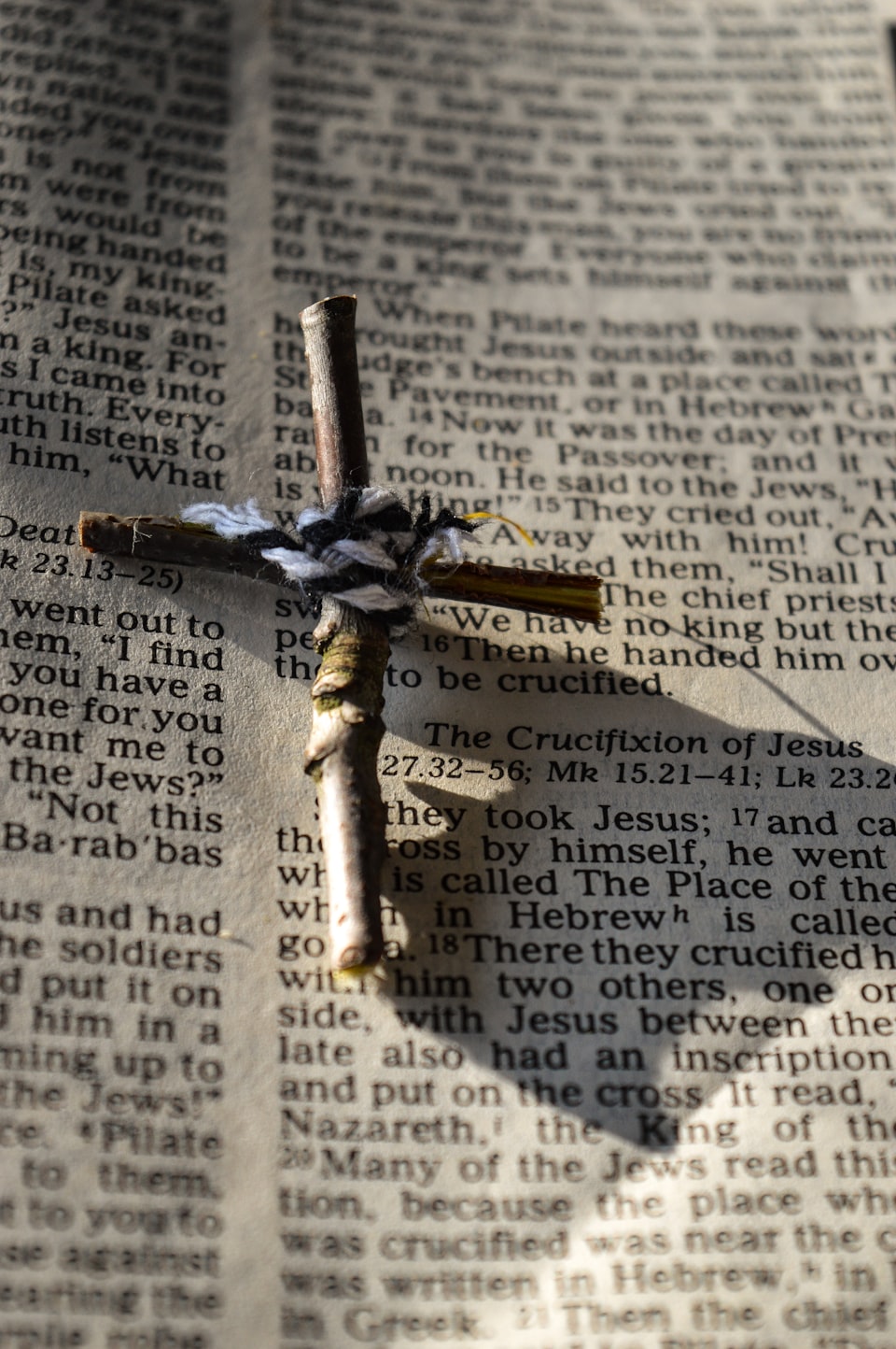 Photo of a small cross on the words of Scripture