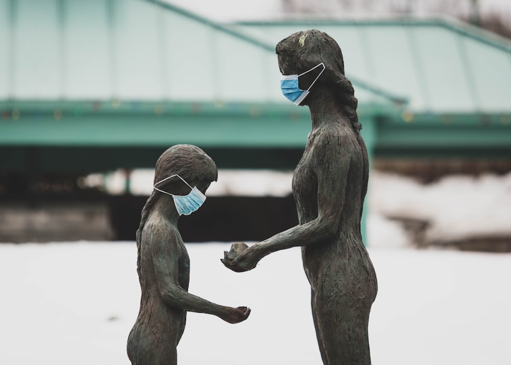 two brown wooden statue of man and woman