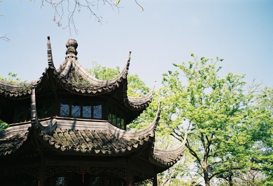 brown and black wooden house near green trees during daytime in Suzhou China