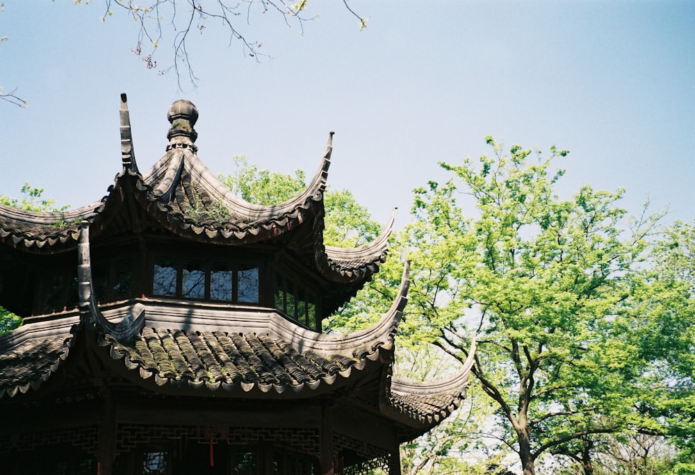 brown and black wooden house near green trees during daytime