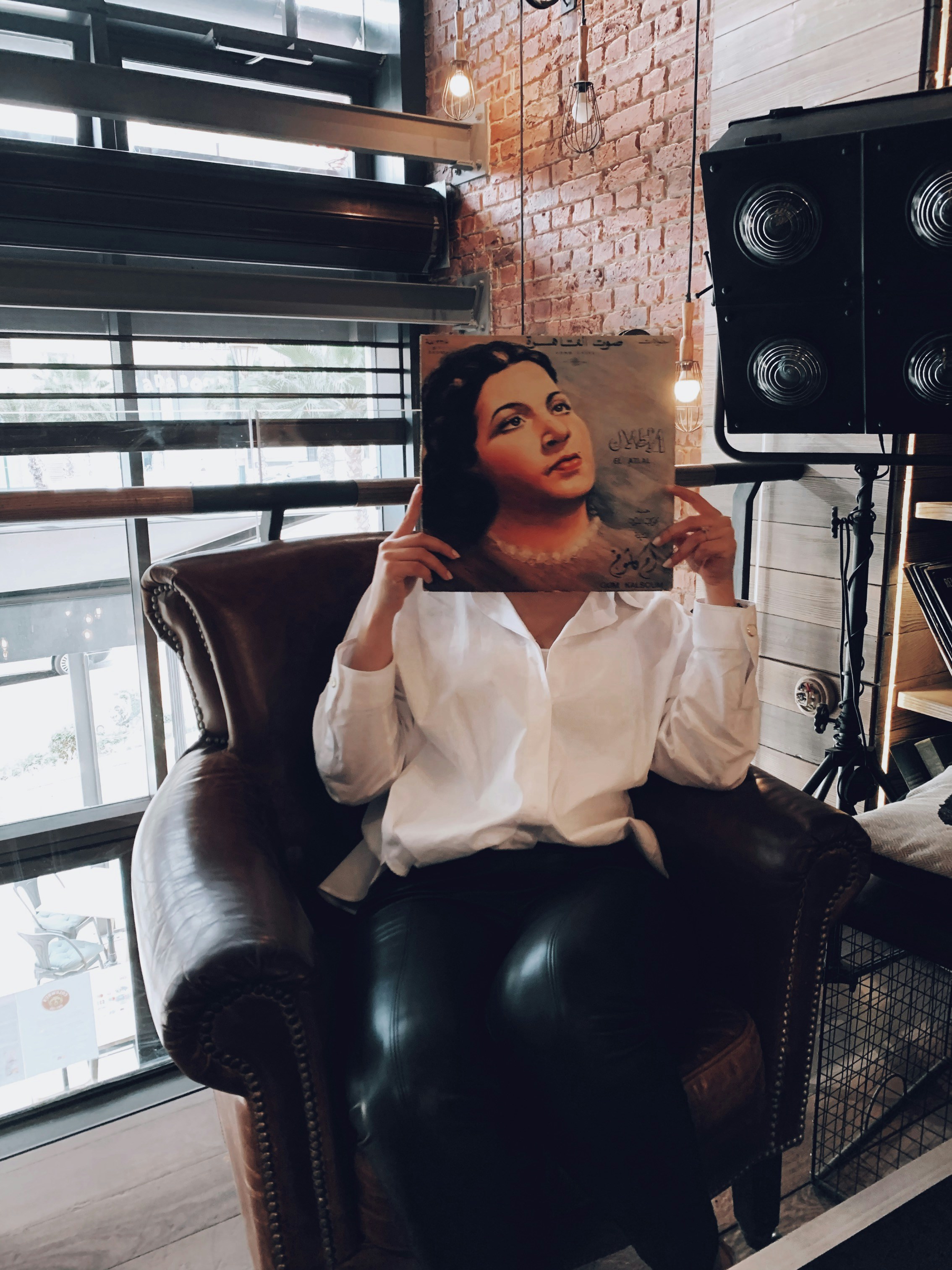 woman in white dress shirt sitting on black leather armchair