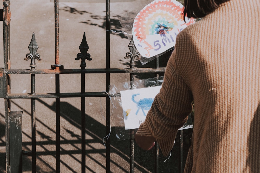 woman in brown long sleeve shirt holding white and blue floral hand fan