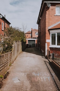 brown brick house near green trees during daytime