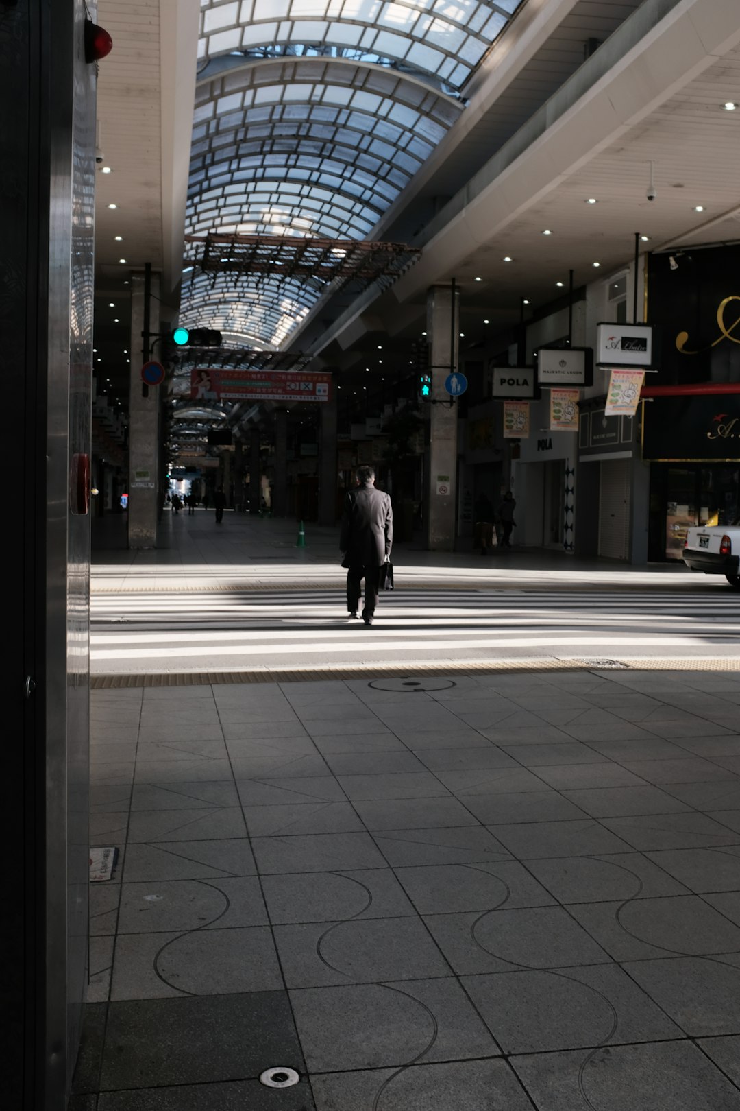 man in black coat walking on sidewalk during night time