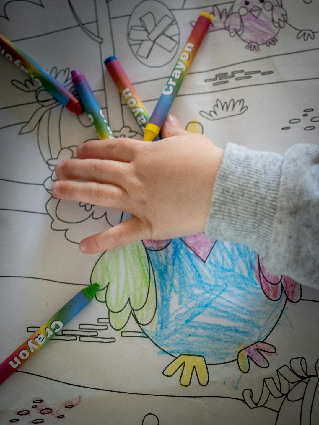 person holding green and white coloring pencils