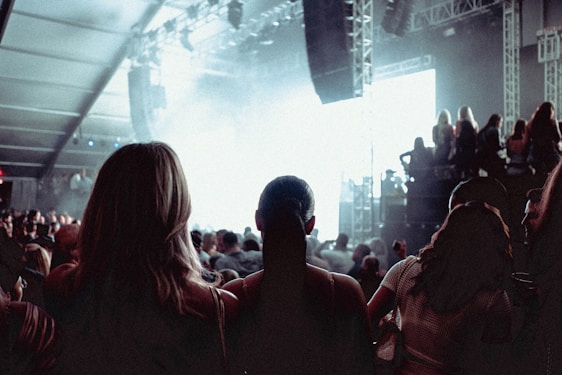A lively crowd at a comedy club enjoying a stand-up performance with bright stage lights.