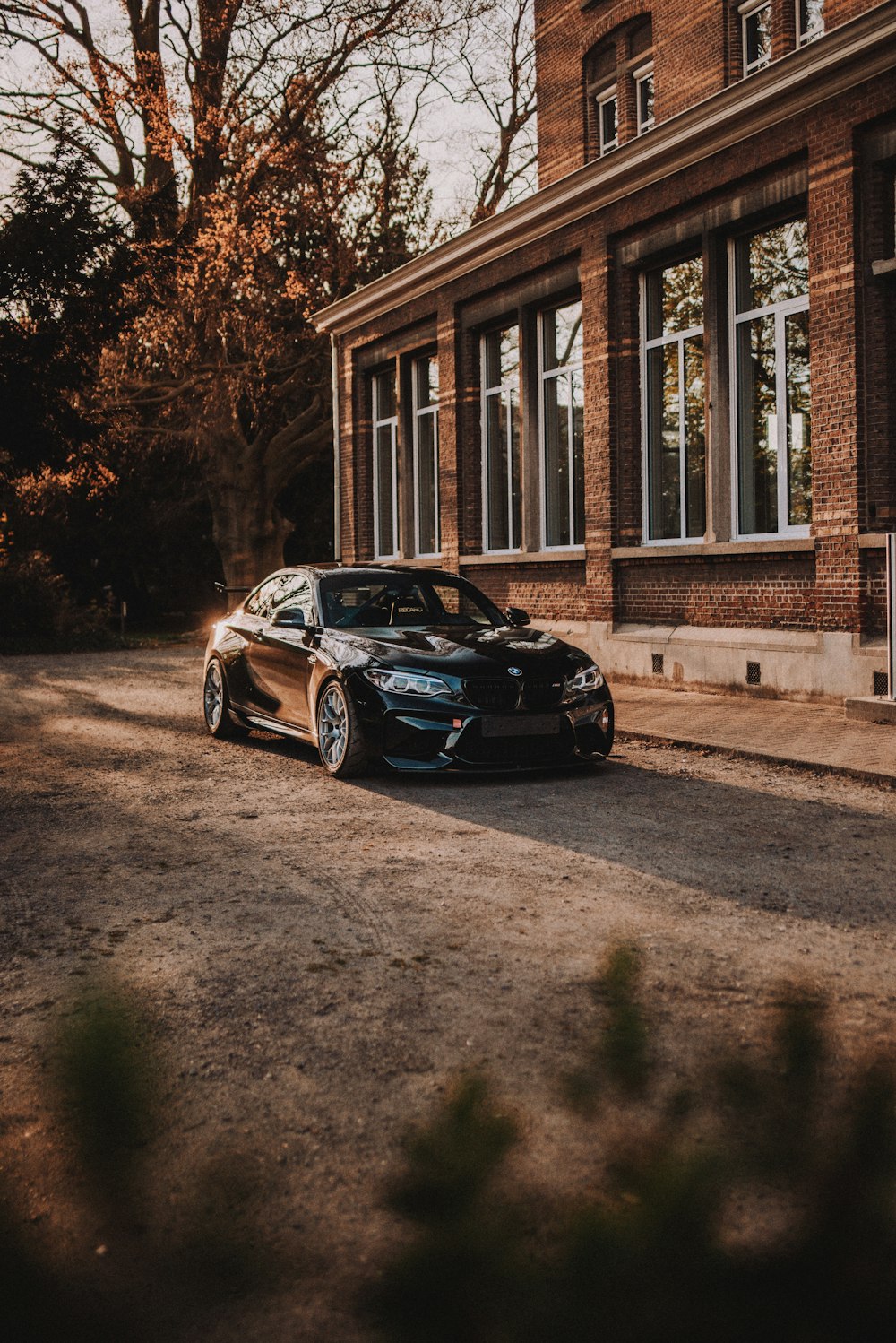 blue bmw m 3 parked on sidewalk during daytime