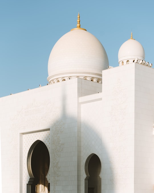 white dome building under blue sky during daytime in Sheikh Zayed Grand Mosque Center United Arab Emirates