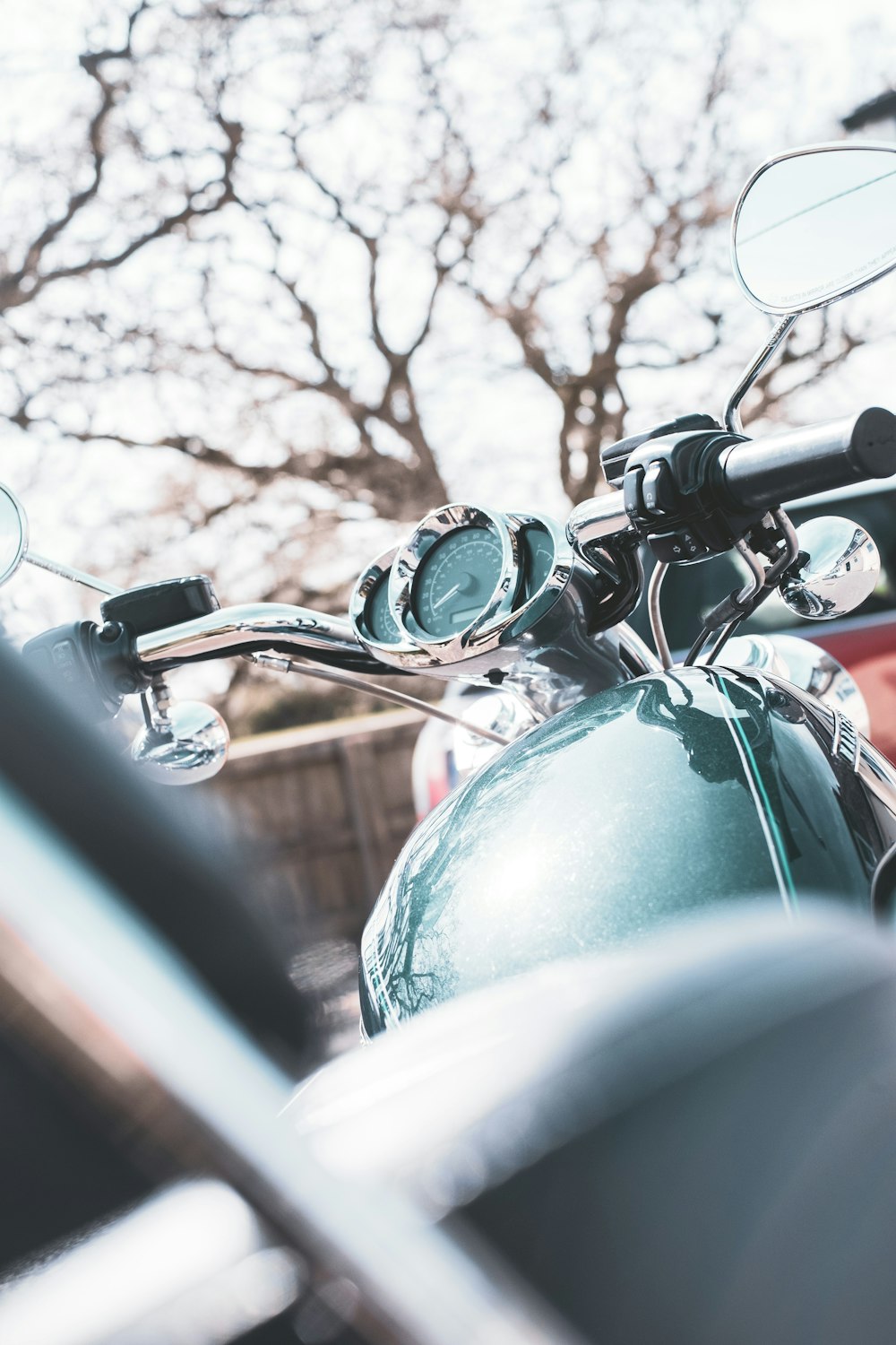 green motorcycle near brown trees during daytime