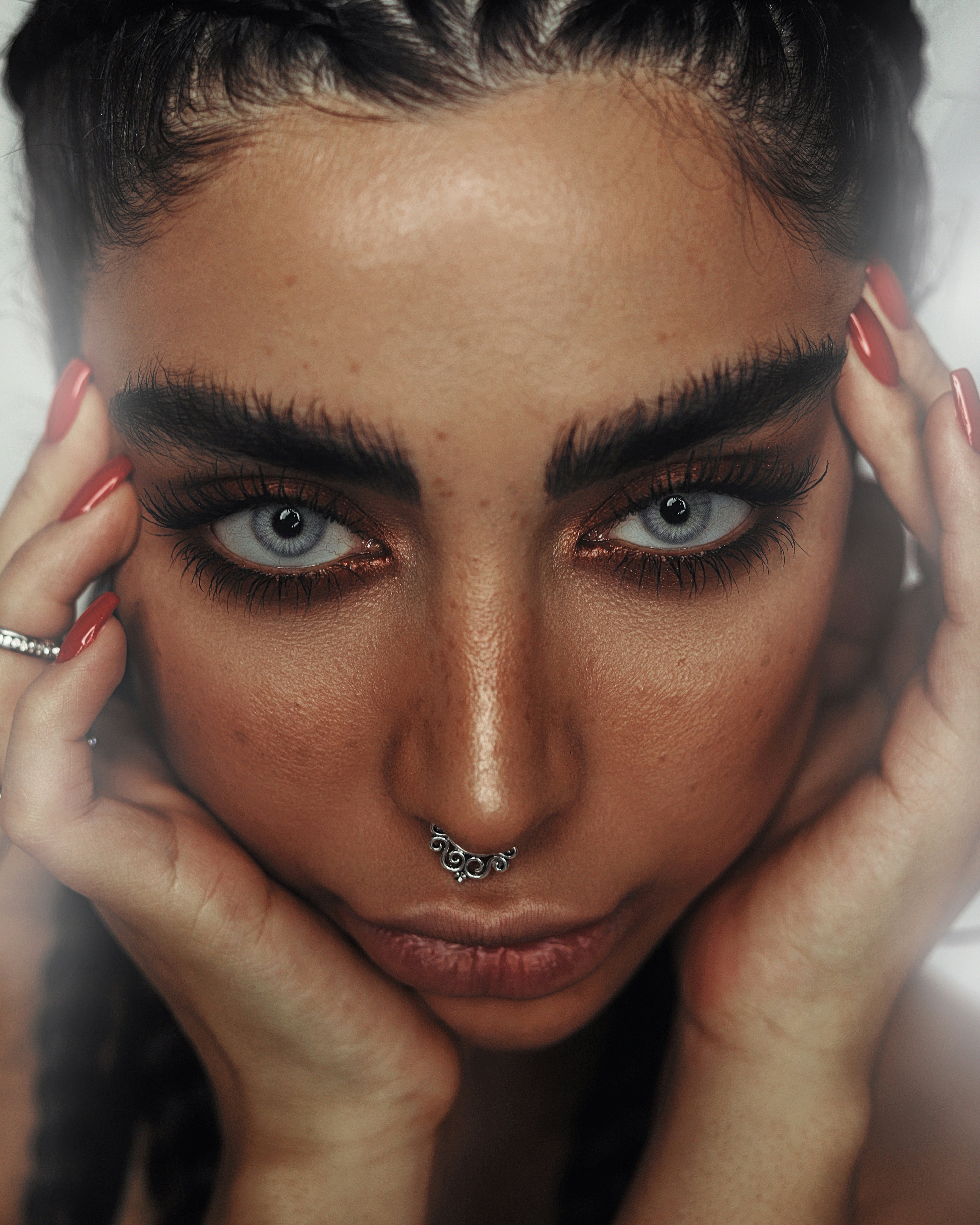 woman with red lipstick holding her face