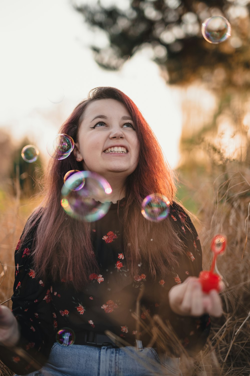 Femme en chemise à manches longues noire soufflant des bulles