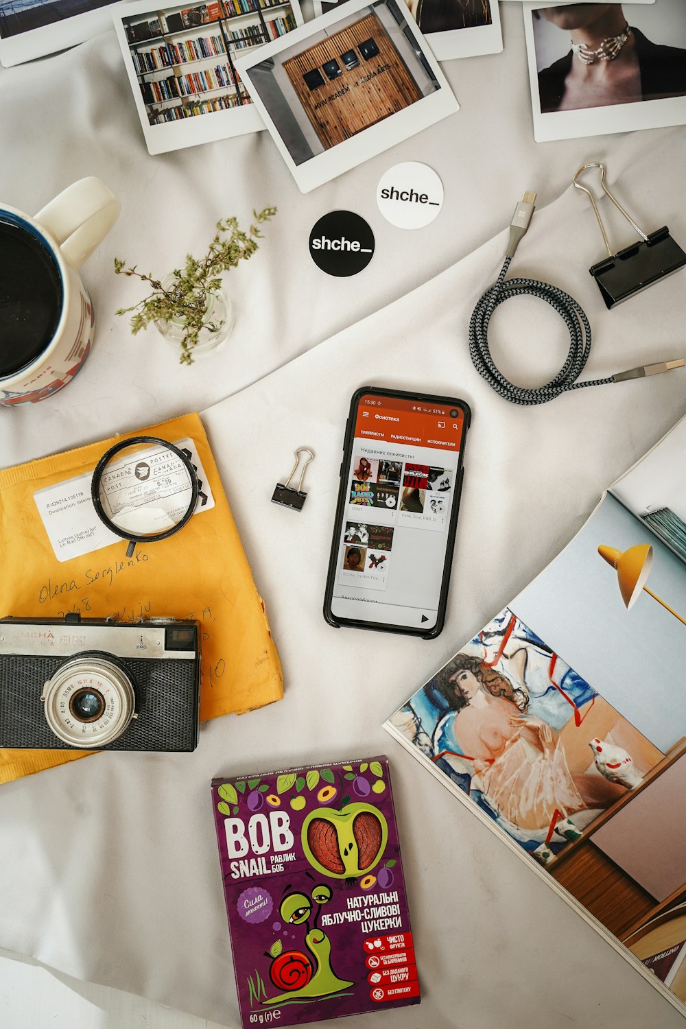 silver iphone 6 beside black and silver camera on white table