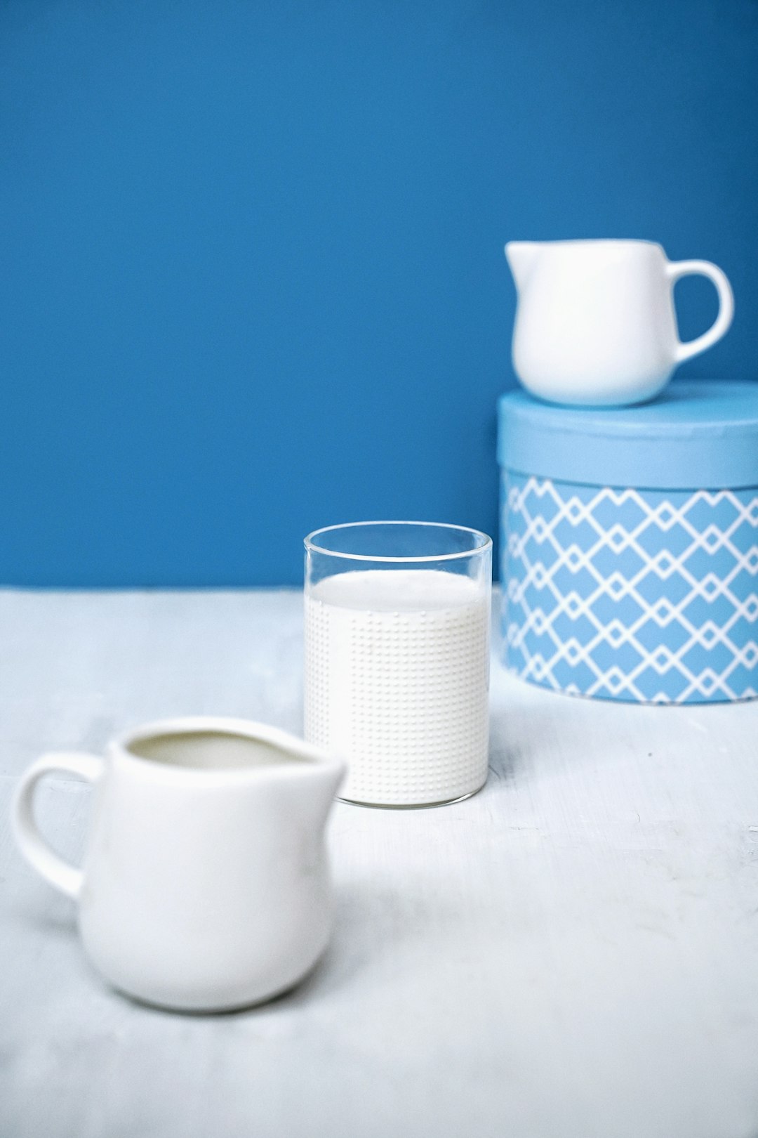 white ceramic mug beside white ceramic mug on white table