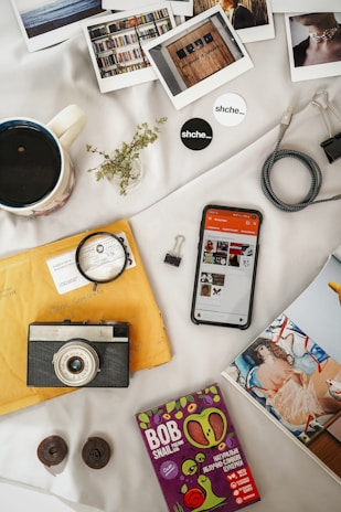 An artistic flat lay of personal items, including books, a camera, and travel souvenirs.