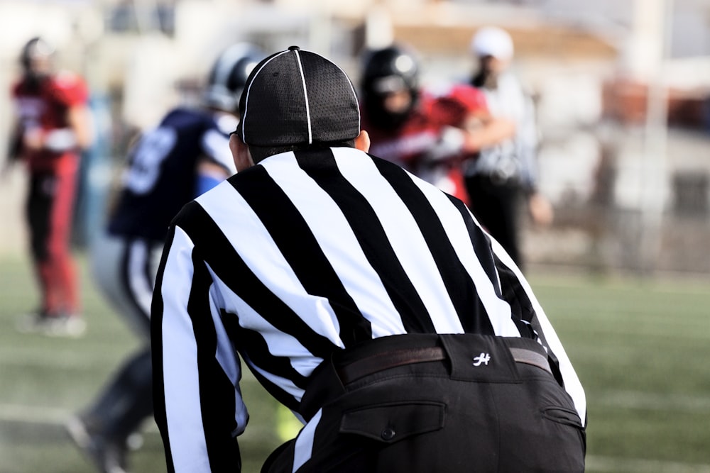 man in black and white striped shirt and black cap