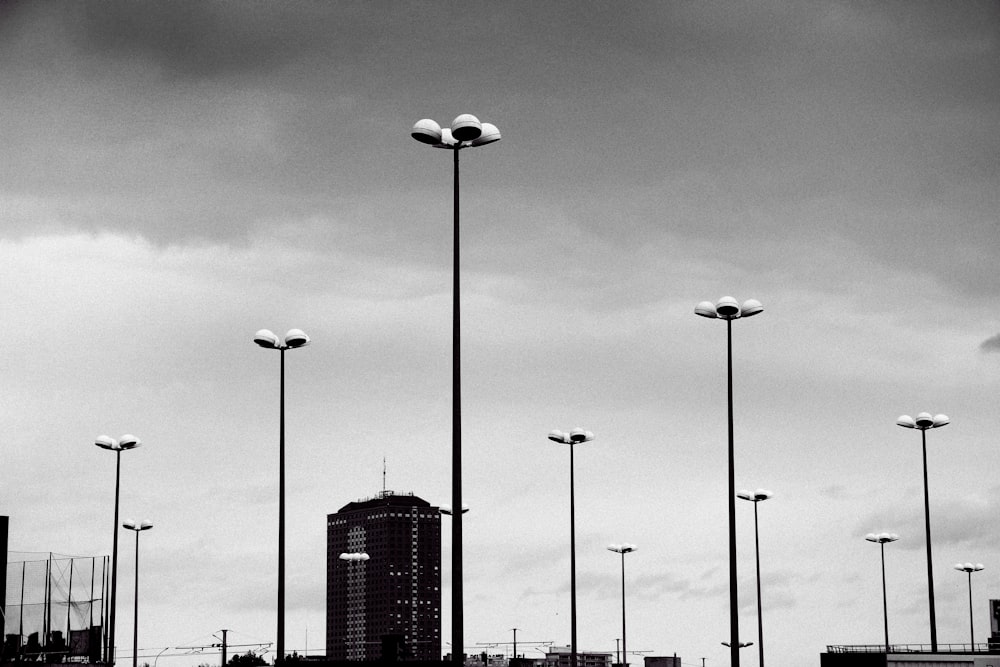 Foto en escala de grises de la farola cerca de un edificio de gran altura