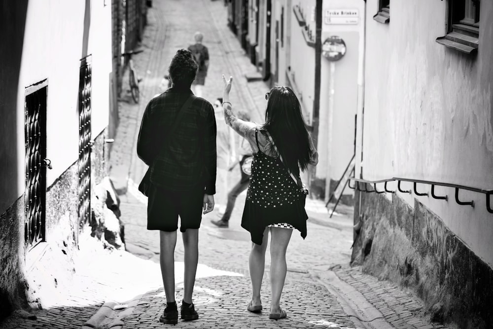 Graustufenfoto von 2 Frauen, die auf dem Bürgersteig spazieren gehen