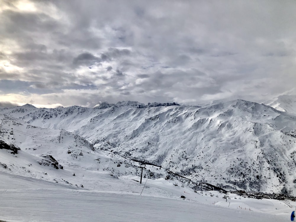 snow covered mountain under cloudy sky