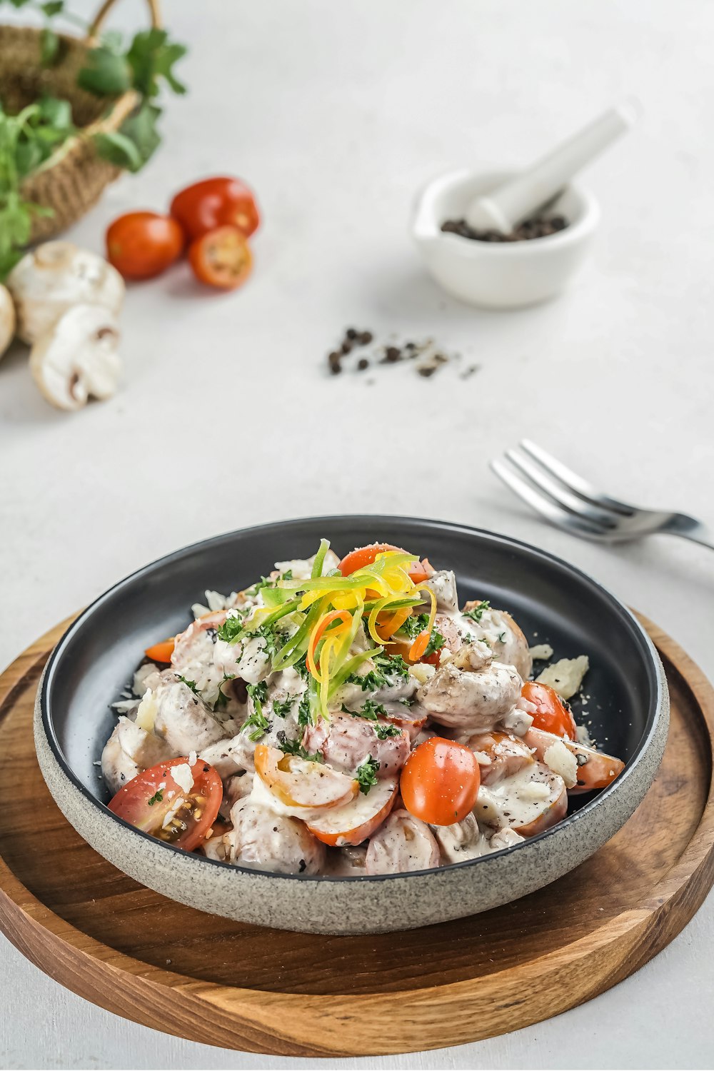 vegetable salad on black ceramic bowl beside stainless steel fork and knife