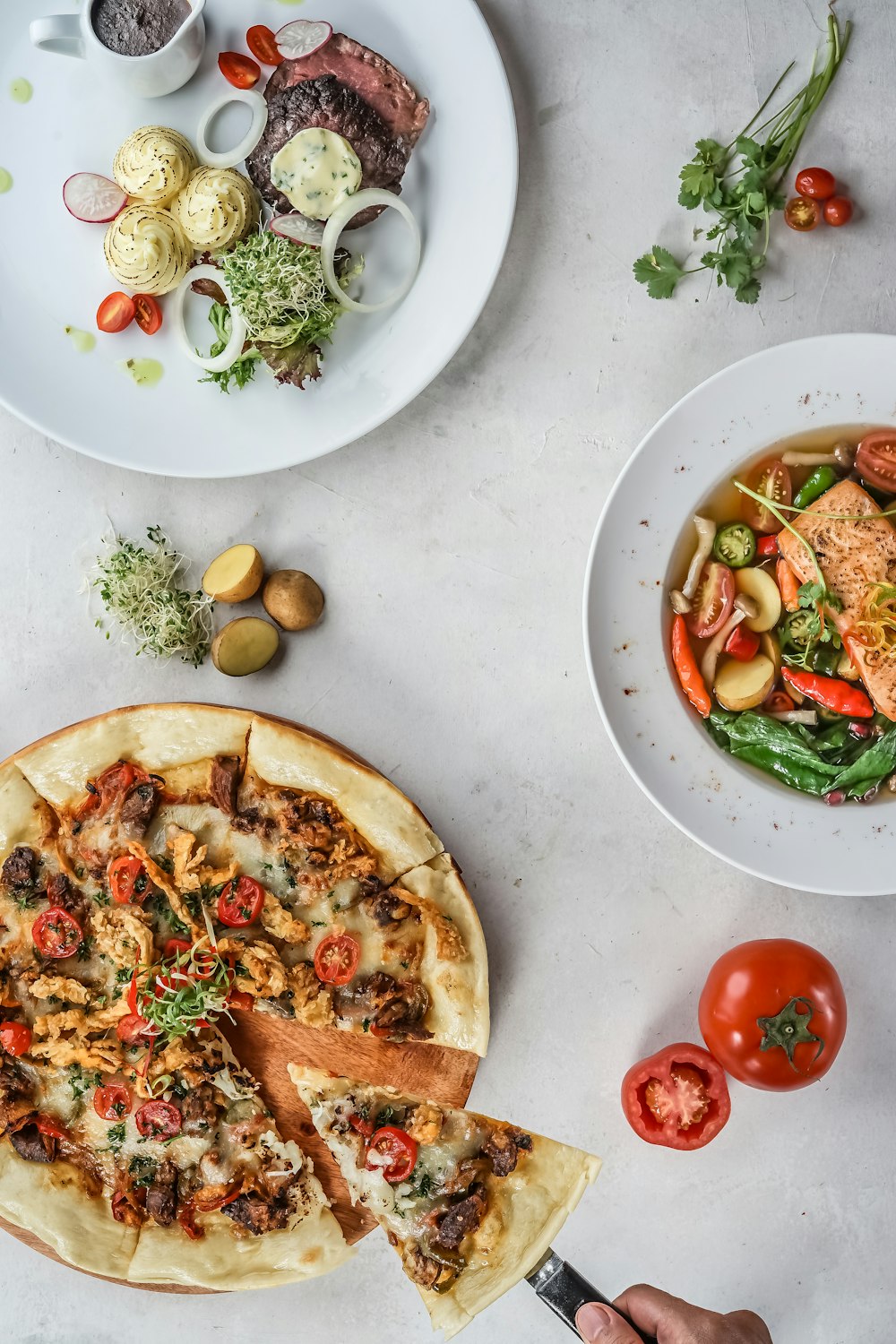 pizza with green leaves and sliced vegetables on white ceramic plate