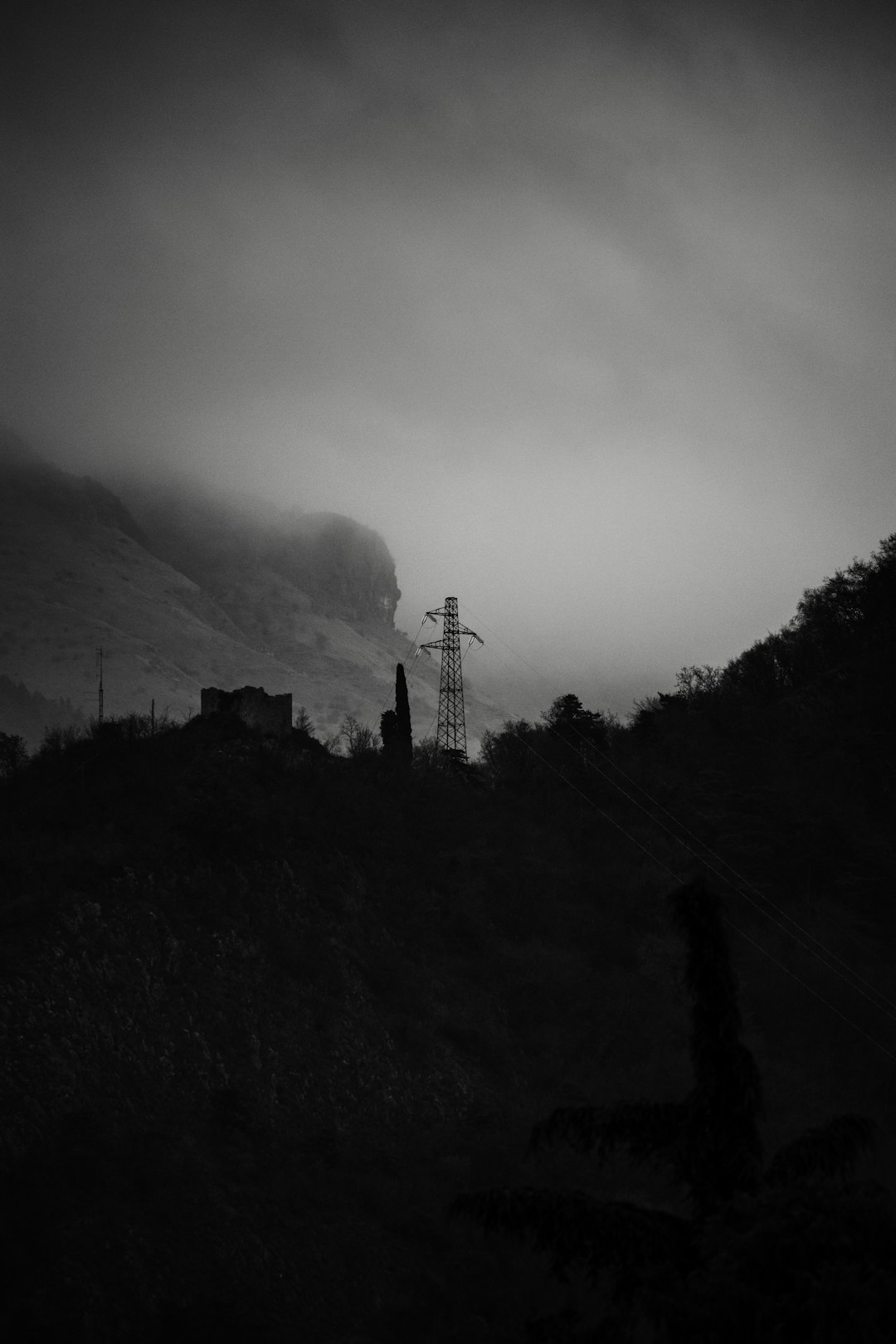 grayscale photo of tower on hill