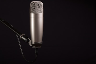 A side-by-side display of condenser and dynamic microphones on a wooden table.