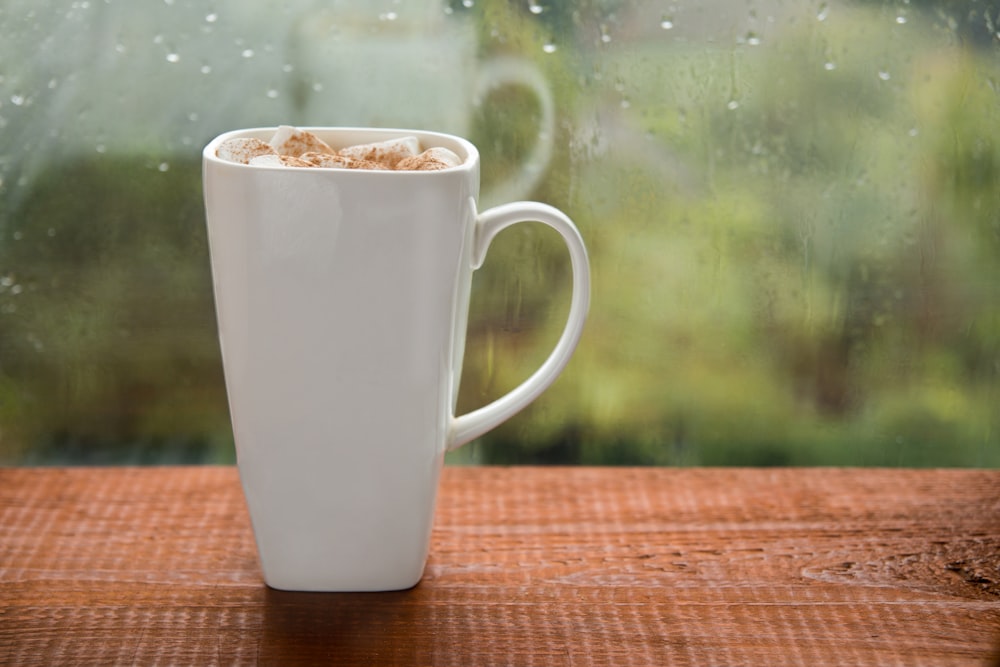 white ceramic mug with brown liquid inside