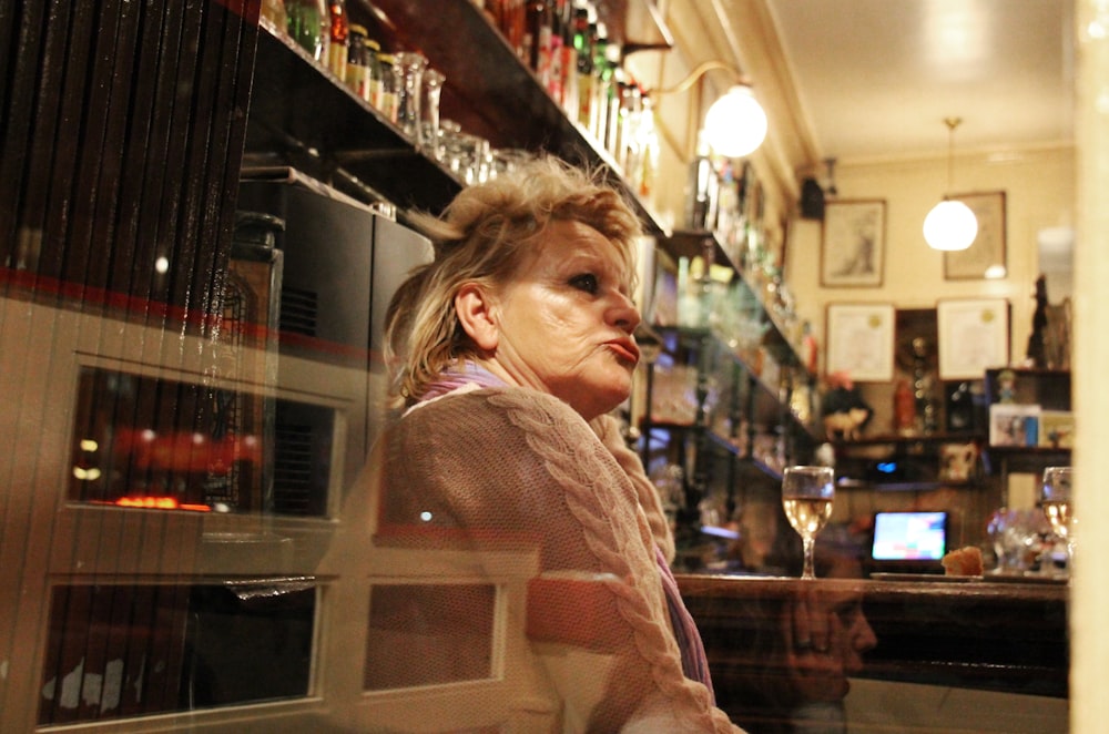 woman in white and brown checkered dress shirt standing beside glass wall