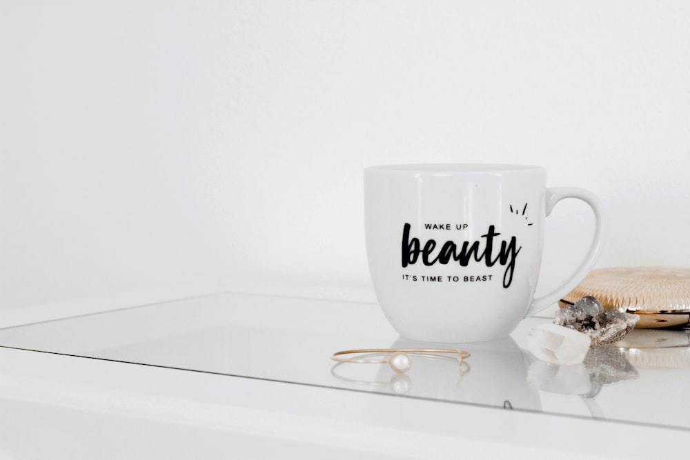 white ceramic mug on white table