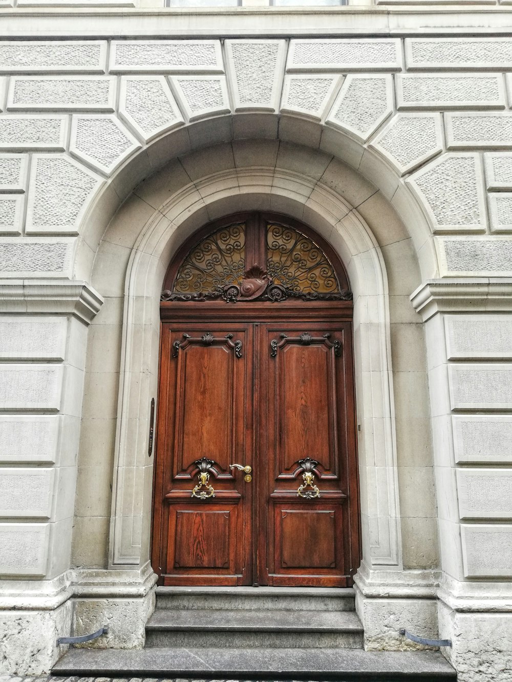 brown wooden door on gray concrete wall