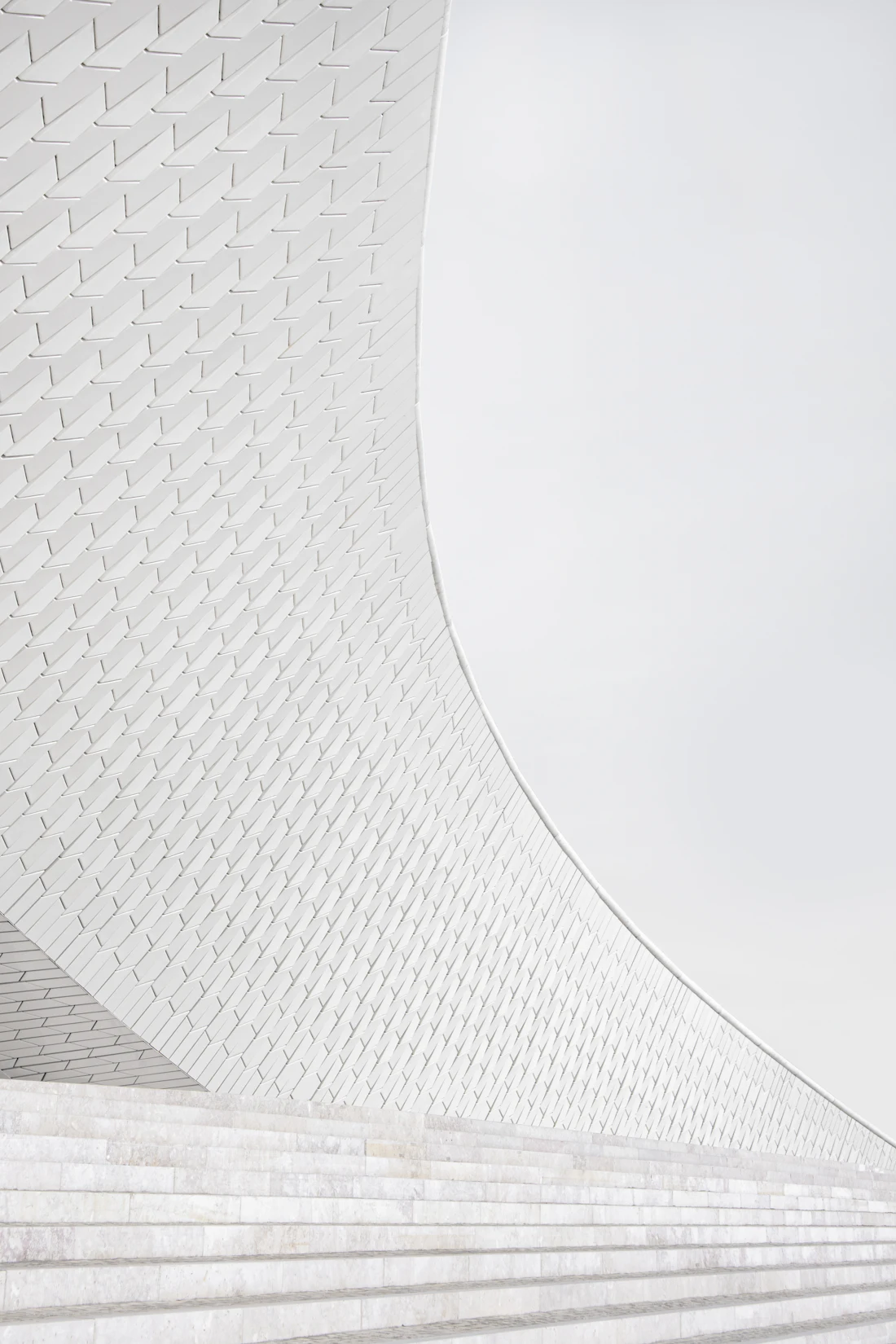 Architettura minimale in marmo bianco che si eleva verso il cielo