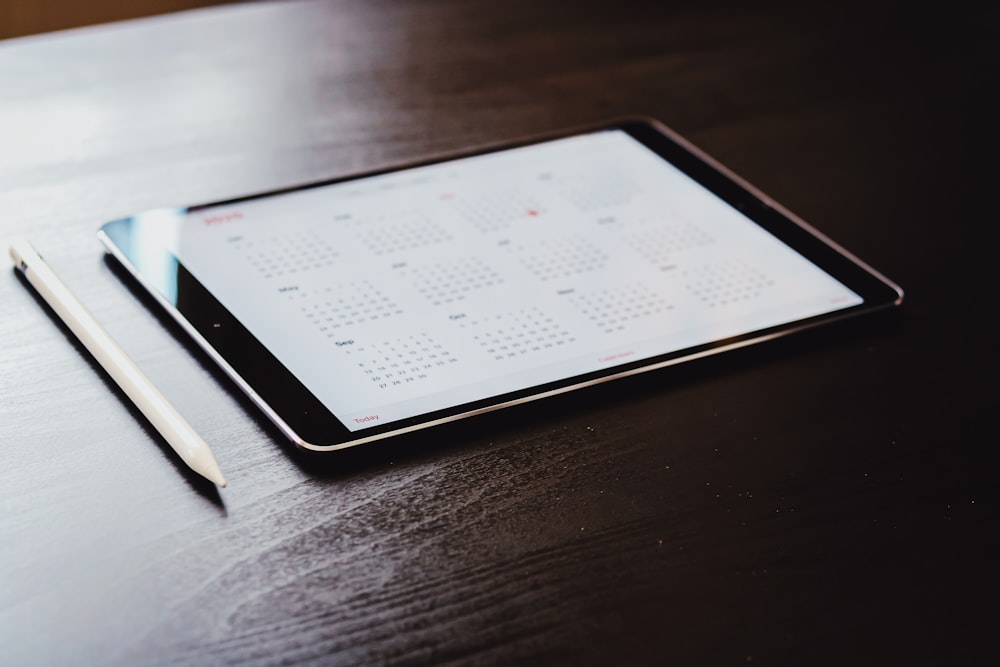 white ipad on brown wooden table