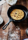 black frying pan on brown wooden table