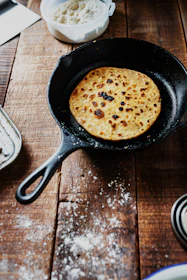 black frying pan on brown wooden table