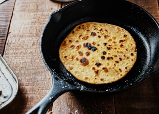 black frying pan on brown wooden table