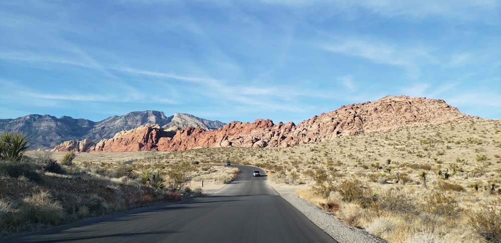 gray asphalt road between brown mountains during daytime