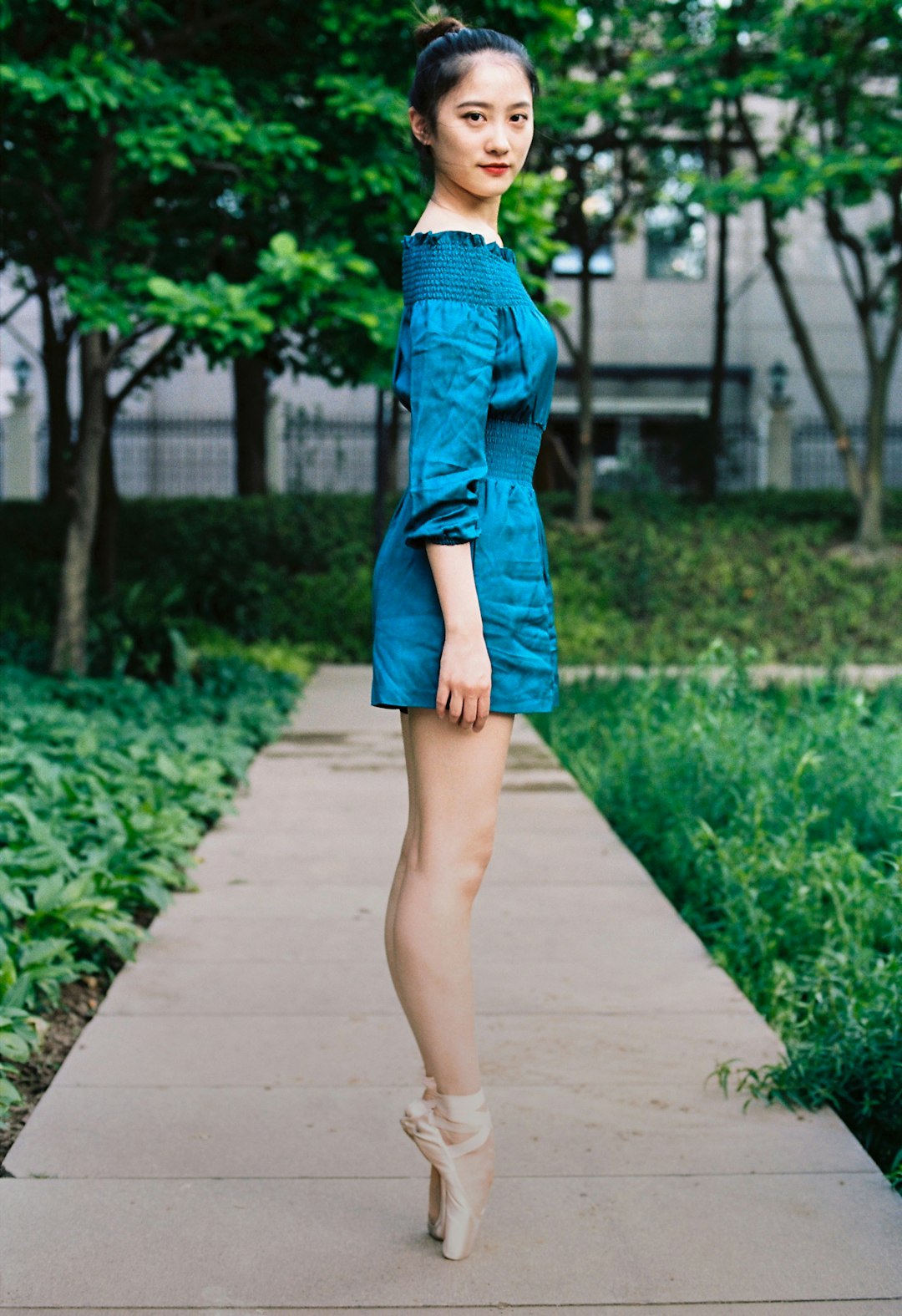 woman in blue denim jacket and blue skirt walking on pathway