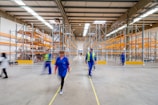 man in blue jacket and blue pants walking on yellow metal frame