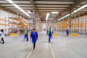 man in blue jacket and blue pants walking on yellow metal frame