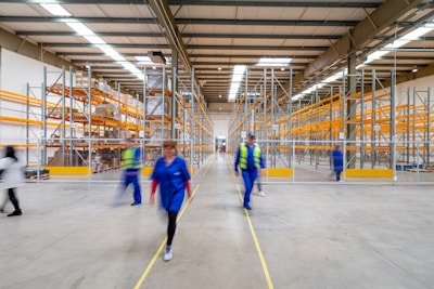 man in blue jacket and blue pants walking on yellow metal frame