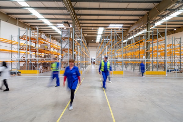 busy warehouse with pallet racking and people walking