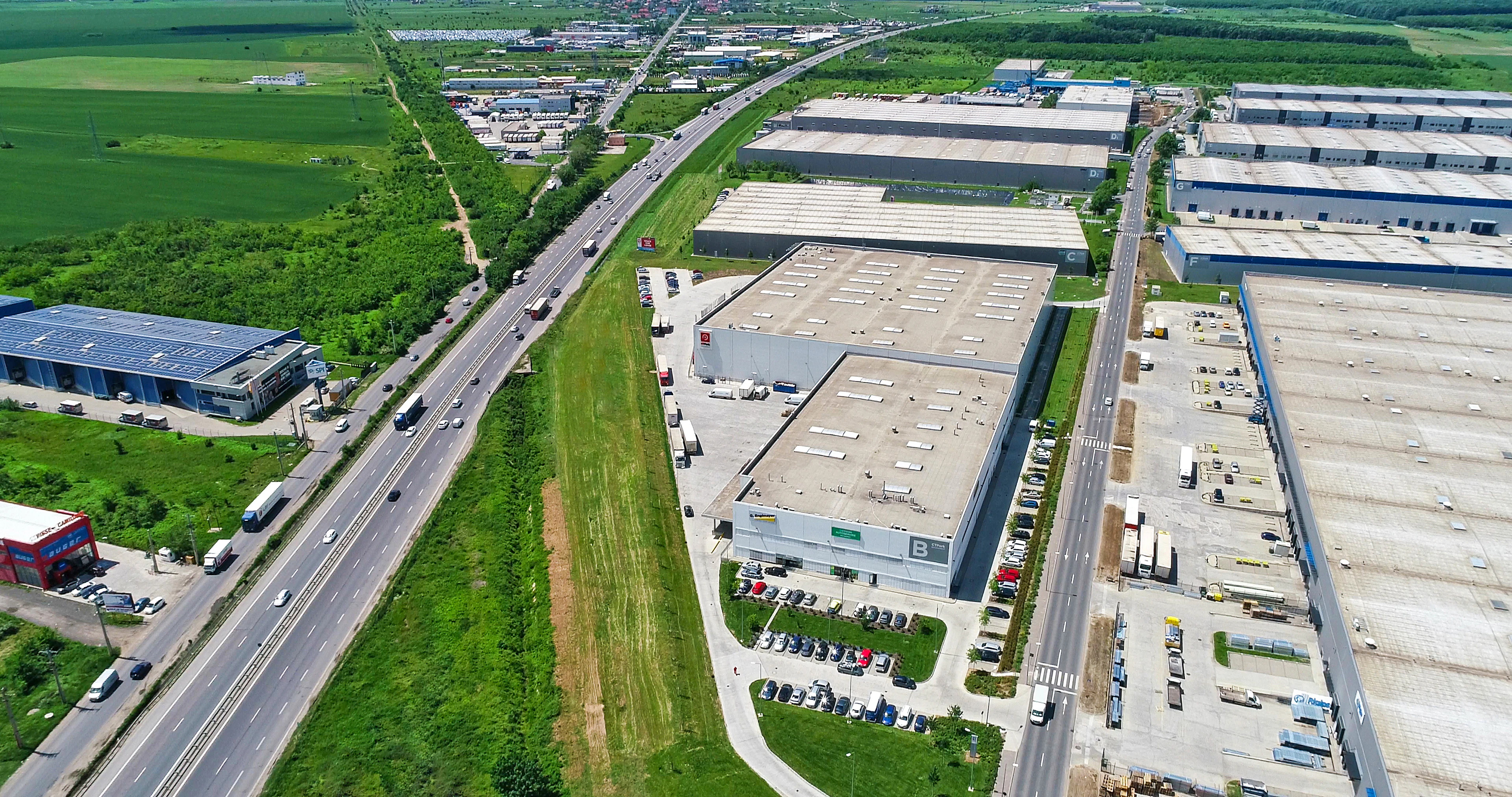Aerial view of a highway beside large distribution warehouses
