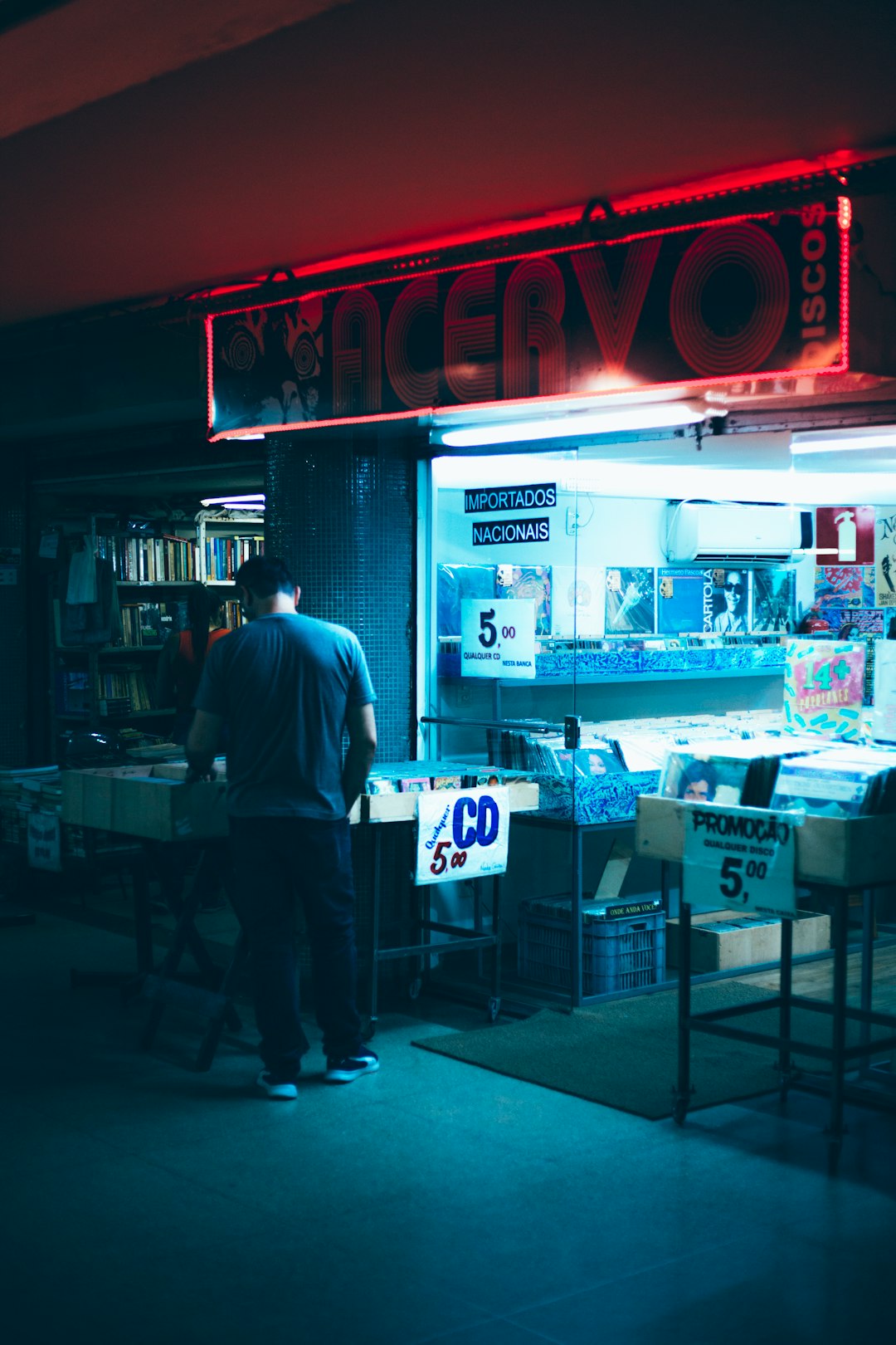 man in blue dress shirt standing near store