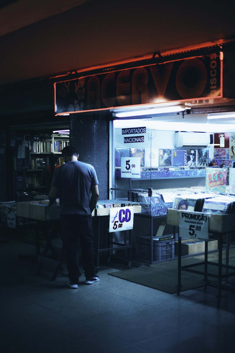 man in blue dress shirt standing near store